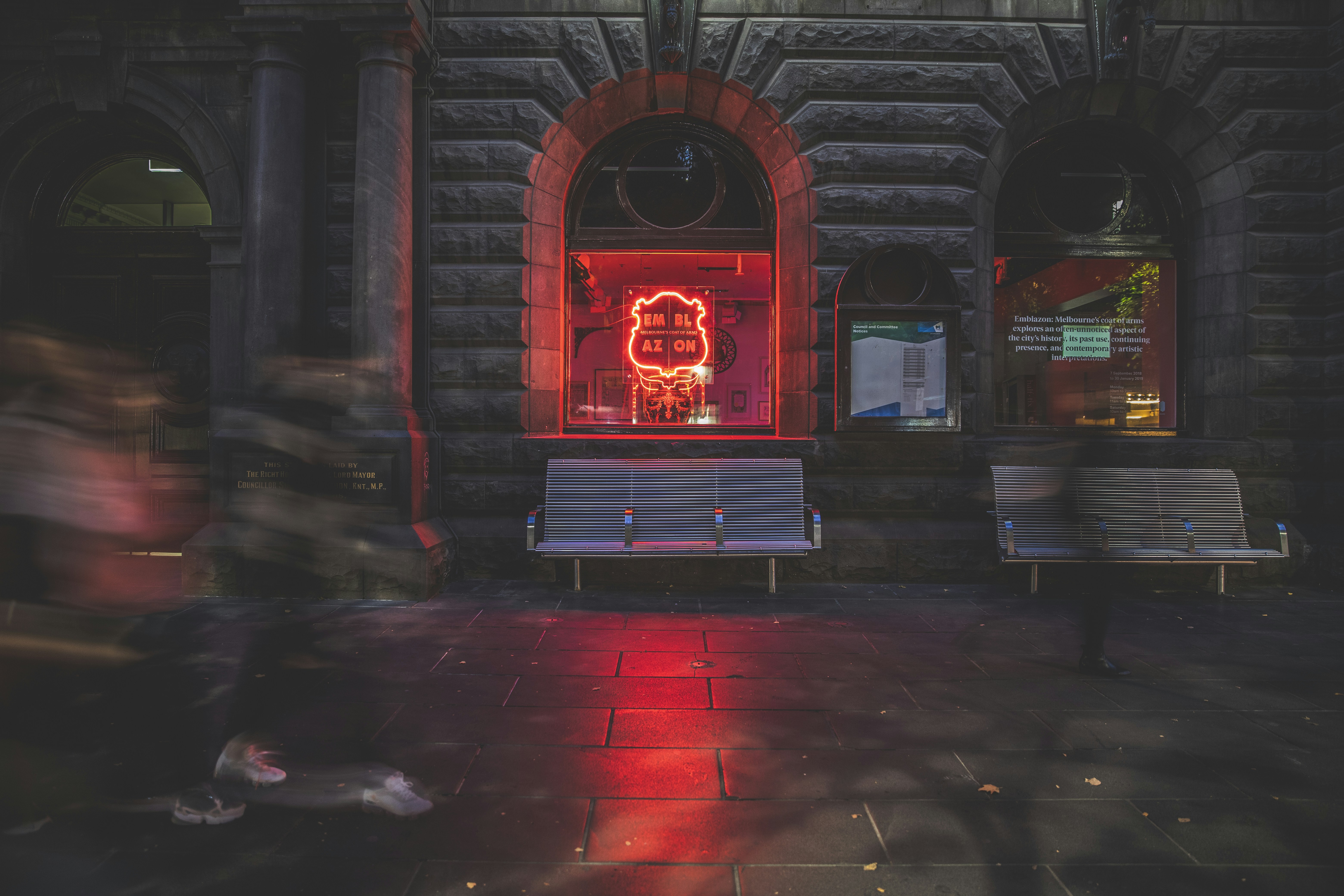 two white benches near red neon signage
